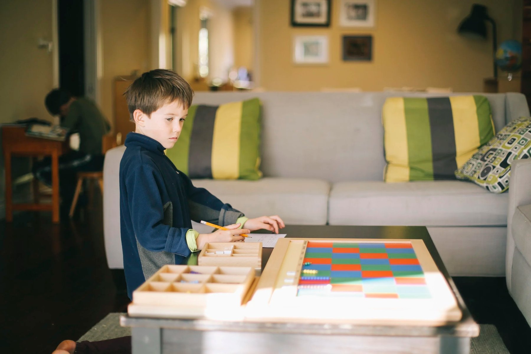 Elementary student working with the Montessori checkerboard multiplication material