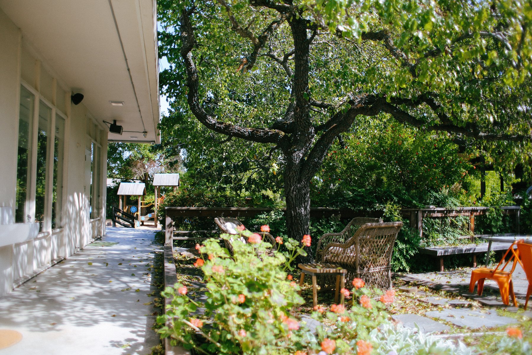 Patio, flowers, and shaded outdoor space at Children’s House