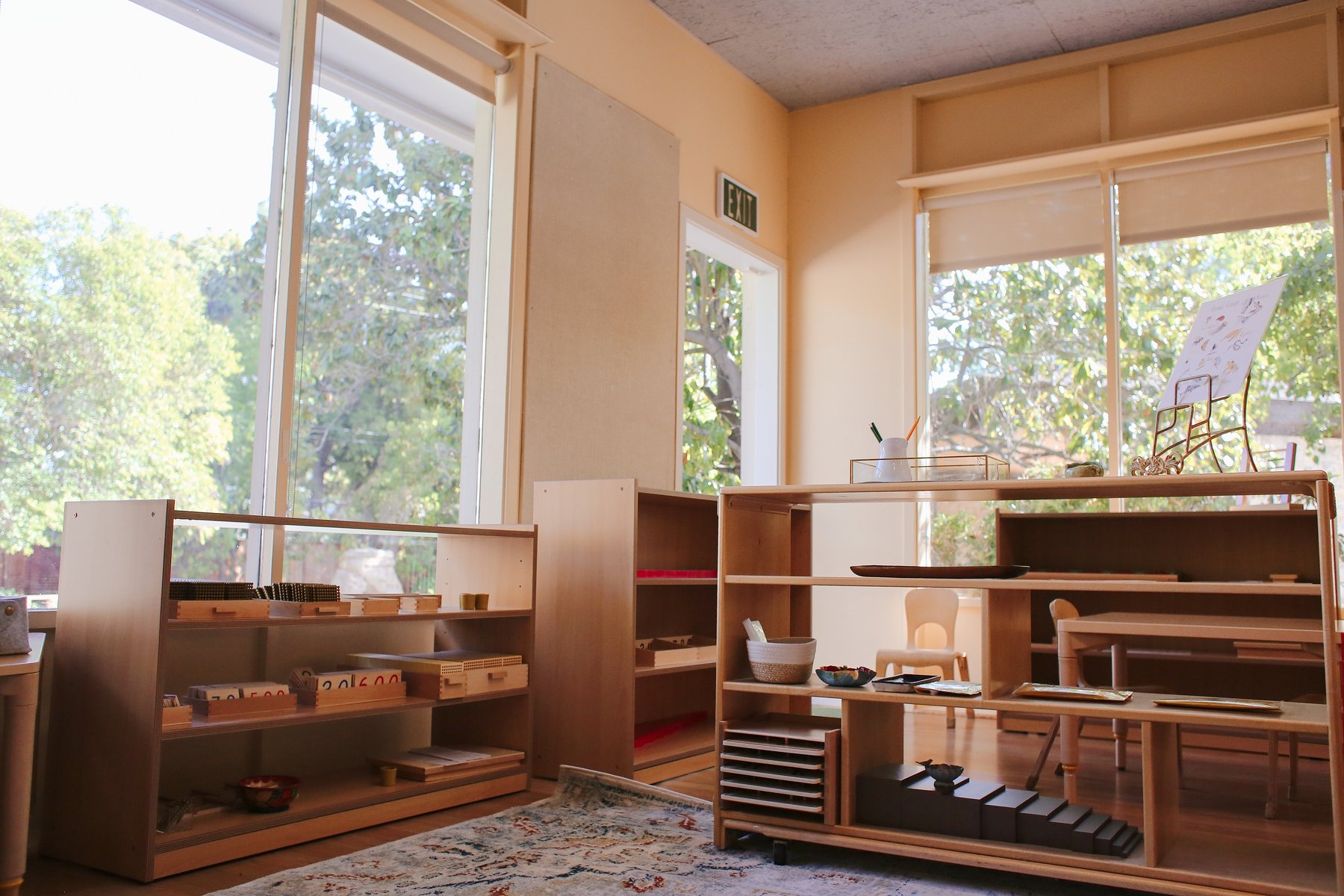Montessori shelves and classroom materials near large windows